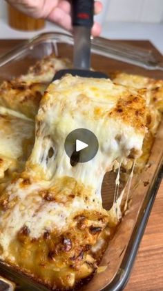 someone is cutting into a cheesy pizza in a pan with a spatula