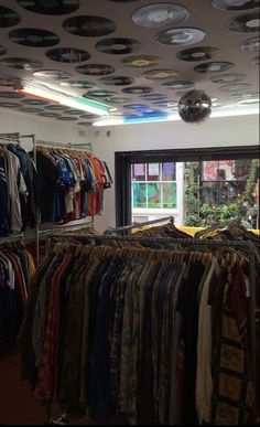 a room filled with lots of clothes and disco balls hanging from the ceiling above it