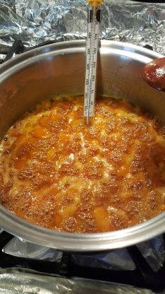 a person is stirring food in a pot on the stove with a measuring stick sticking out of it