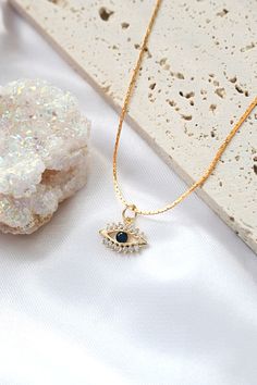 "Our evil eye necklace is a timeless minimalist necklace with an evil eye pendant with cubic zirconia gemstones and a central cz sapphire. This necklace is perfect to wear as everyday jewelry and combined layered with other necklaces. Hypoallergenic, lightweight and minimalist.  D E T A I L S ✨ Chain Material: 24 karat gold plated over stainless steel. ✨ Chain Length: 40 cm + 5.5 cm / 15.7 inch + 2.1 inch  (Adjustable extension). ✨ Pendant Length: 1 cm / 0.4 inch. ✨ Pendant Width: 2.1 cm / 0.8 i Delicate Necklace Gold, Evil Eye Necklace Gold, Evil Eye Pendant, Evil Eye Charm, Evil Eye Necklace, Sapphire Necklace, Elegant Necklaces, Minimalist Necklace, Eye Necklace