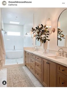 a bathroom with two sinks and a bathtub next to a large mirror on the wall