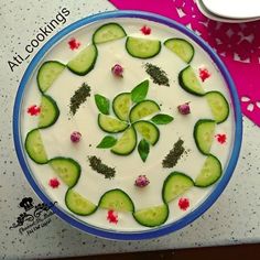 cucumber slices are arranged in the center of a bowl with leaves and flowers on it