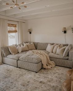 a living room filled with furniture and a large rug on the floor in front of a window