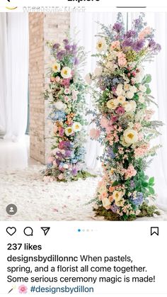 two tall floral arrangements in front of a brick wall