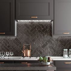 a kitchen with gray cabinets and marble counter tops, copper accents on the backsplash