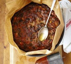 a wooden table topped with a bowl of chili