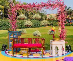 an outdoor seating area is decorated with pink flowers