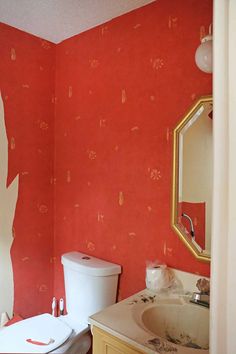 the bathroom is painted bright red and has an orange wall with white paint on it