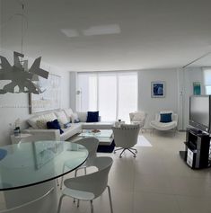 a living room filled with furniture and a flat screen tv sitting on top of a glass table