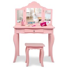 a pink vanity table with a mirror and stool