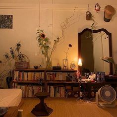 a living room filled with furniture and lots of books on top of a wooden floor