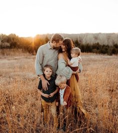 a family standing together in a field at sunset