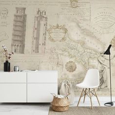 a white dresser sitting next to a wall with a map on it's side