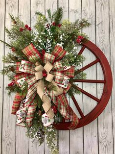 a christmas wreath on top of a wagon wheel