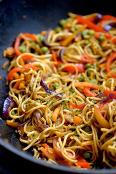 a pan filled with noodles and vegetables on top of a stove