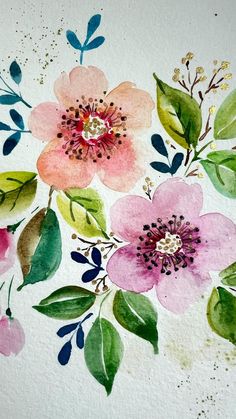 watercolor flowers painted on white paper with green leaves