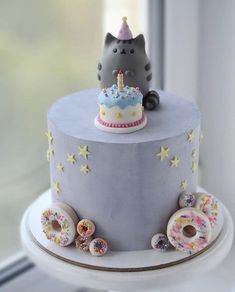 a birthday cake with donuts and a cat on top