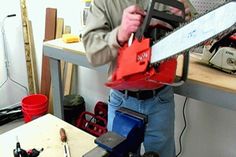 a man holding a chainsaw in his hands while standing next to a workbench