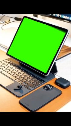 an open laptop computer sitting on top of a wooden desk next to a cell phone