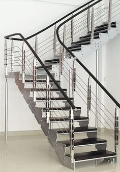 a set of stairs with metal handrails in an empty room next to a white wall