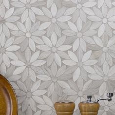 two wooden vases sitting next to each other in front of a wall with a flower pattern on it