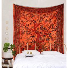 an orange tapestry hanging over a bed in a bedroom