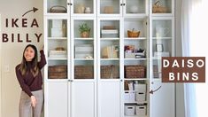 a woman standing in front of a white bookcase with baskets on the bottom shelf