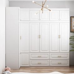 a bedroom with white closets and drawers in the corner, along with a baby's crib