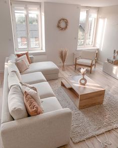 a living room filled with lots of furniture next to two windows and a rug on the floor