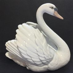 a white swan statue sitting on top of a black surface