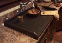 a kitchen sink with a wooden bowl on it