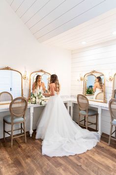 the bride is getting ready to go into her wedding dress in front of the mirror