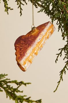 an ornament hanging from a tree branch that is shaped like a piece of cheese