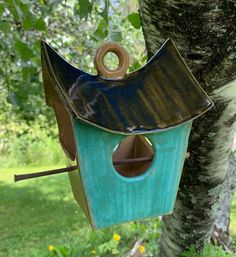 a bird house hanging from the side of a tree