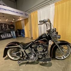 a black and gold motorcycle is parked in front of a yellow curtain at an event