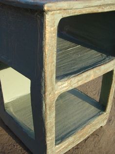 an old wooden shelf sitting in the dirt with no one around it or someone else