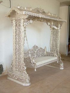 an ornate white bed frame in the middle of a room