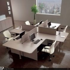 an office cubicle with multiple desks and chairs in front of a large window