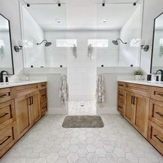 a bathroom with two sinks, mirrors and wooden cabinets in it's center area