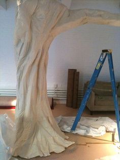 a large tree that is in the middle of being worked on by a man with a ladder