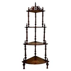 three tiered wooden shelf with ornate carvings on the top and bottom, against a white background