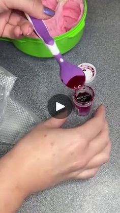 a person is using a toothbrush to brush their teeth with pink and purple paste