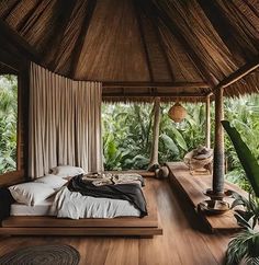 a bed sitting on top of a wooden floor next to a lush green forest filled with trees