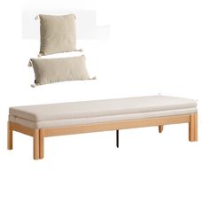 a bed with two pillows on top of it next to a white pillow and wooden frame