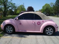 a pink car with flowers painted on the side