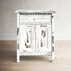 an old white cabinet is sitting on the floor