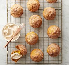 muffins cooling on a wire rack with frosting and a spoon next to them