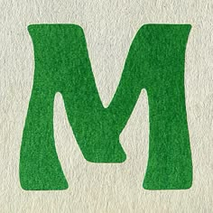 the letter m is made up of green grass and it's letters have been cut out