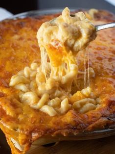 a spoonful of macaroni and cheese being lifted from a casserole dish