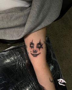 a person with a creepy face tattoo on their arm